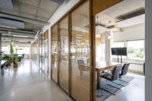 Modern kantoorinterieur aan de Anthony Fokkerweg met glazen vergaderruimtes, houten details en veel daglicht.